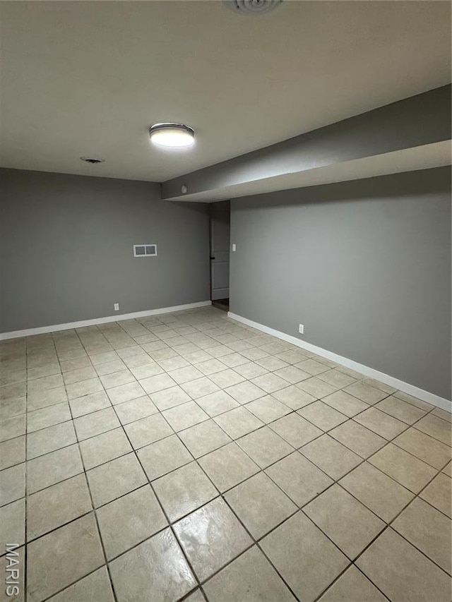 finished basement featuring light tile patterned floors and baseboards