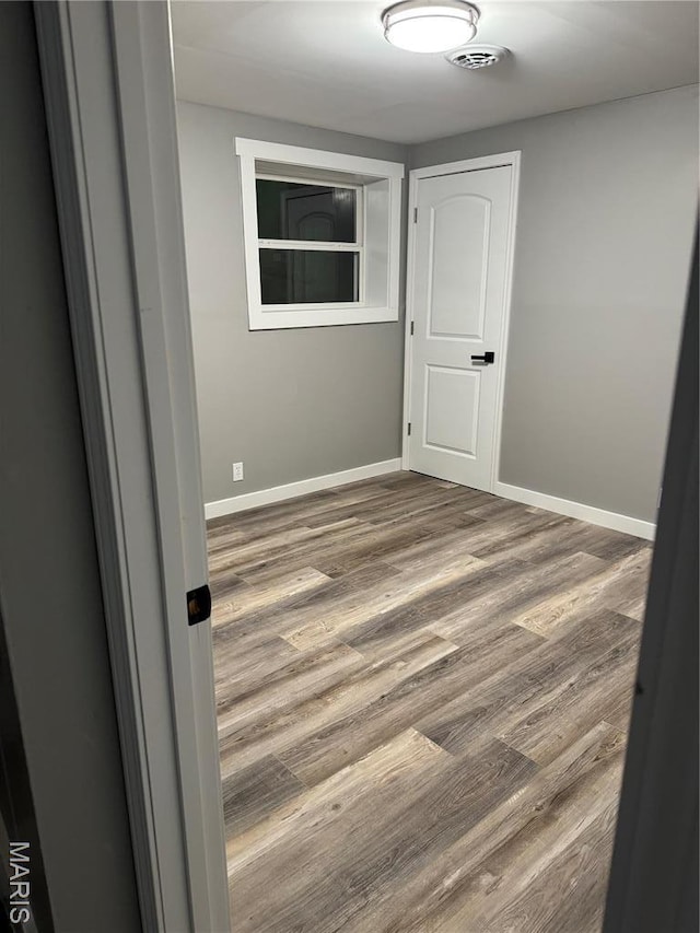 unfurnished room featuring wood finished floors and baseboards