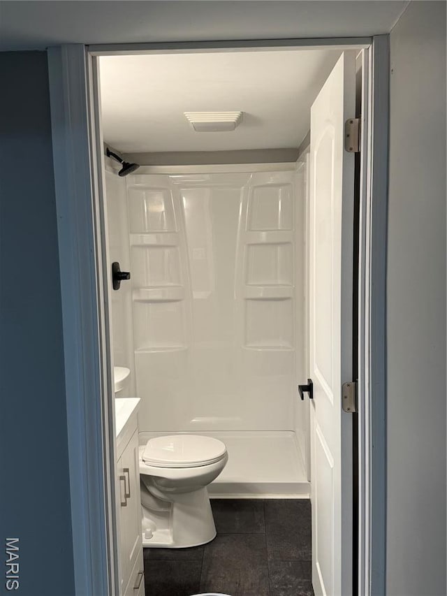 bathroom featuring toilet, tile patterned floors, a shower stall, and vanity