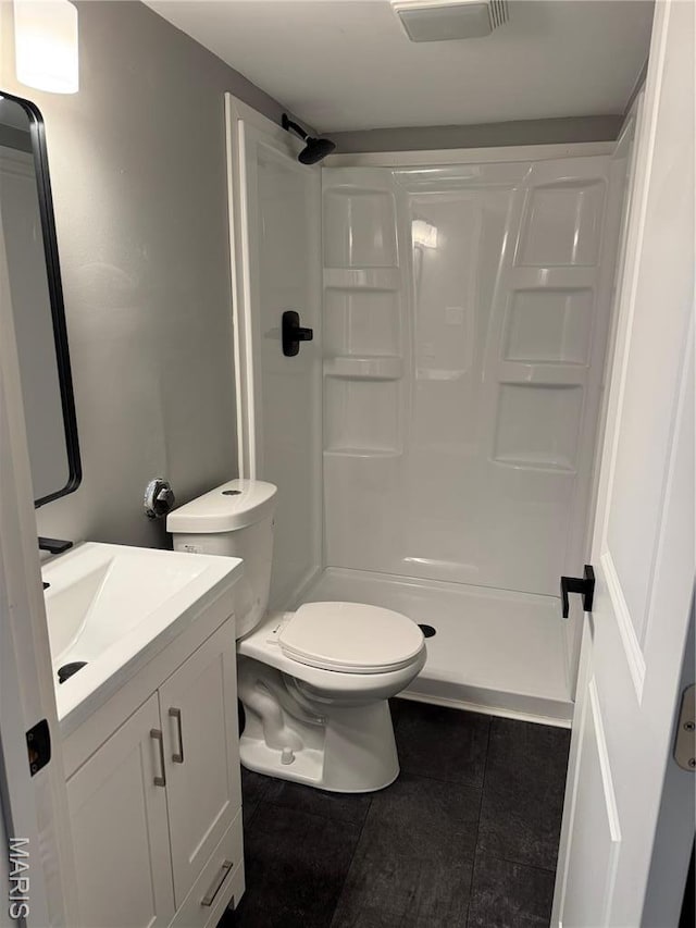 full bathroom featuring tile patterned flooring, a shower stall, vanity, and toilet
