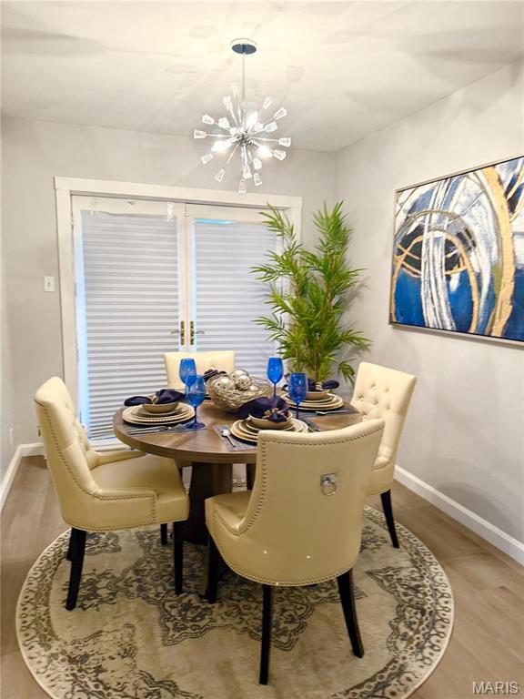7008 Rohn Dr, Saint Louis, MO 63121 - dining room featuring a chandelier, light wood finished floors, and baseboards