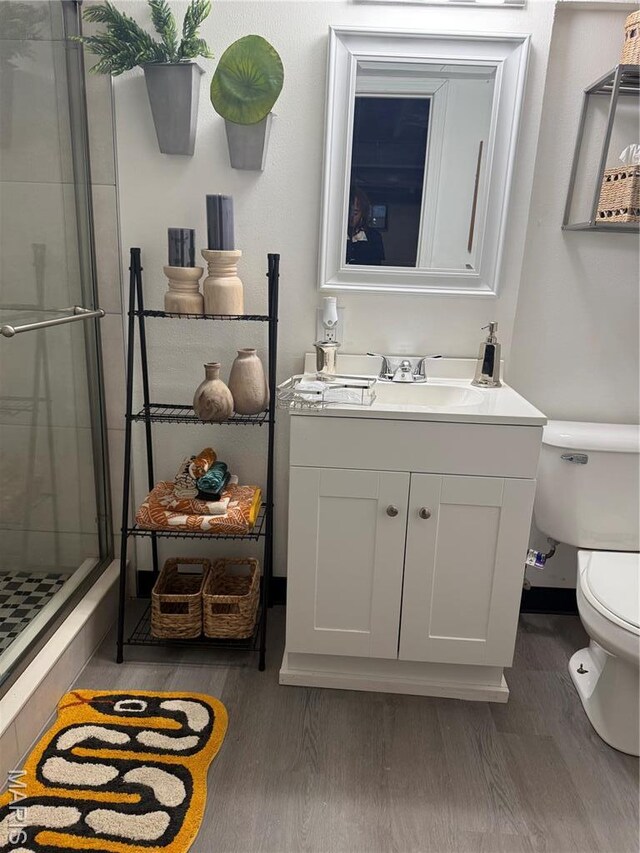 7008 Rohn Dr, Saint Louis, MO 63121 - bathroom with wood finished floors, a stall shower, toilet, and vanity