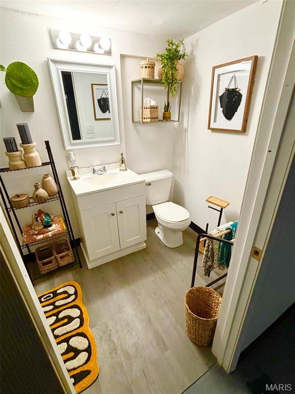 7008 Rohn Dr, Saint Louis, MO 63121 - bathroom with toilet, wood finished floors, and vanity