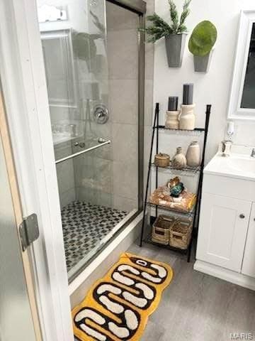 7008 Rohn Dr, Saint Louis, MO 63121 - full bath featuring a stall shower, wood finished floors, and vanity