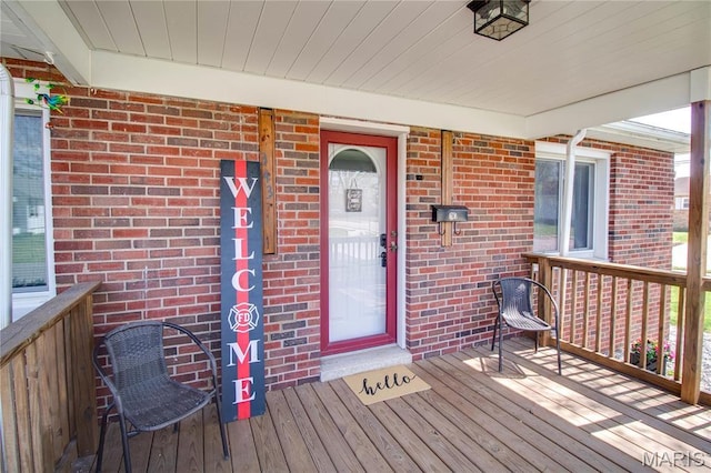property entrance featuring brick siding and a porch
