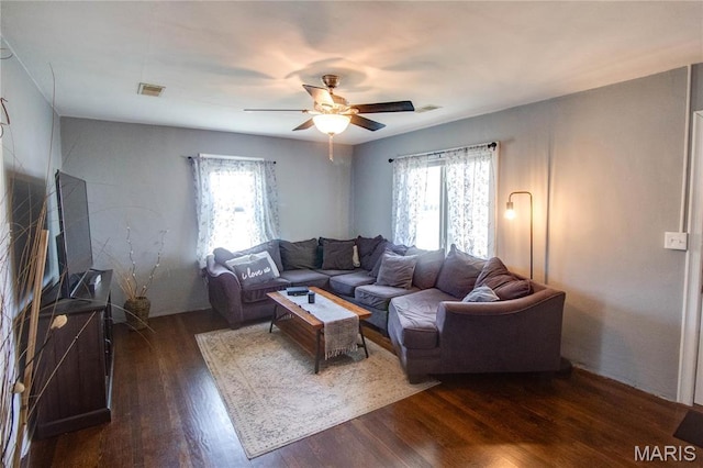 living area with plenty of natural light, dark wood-style floors, and a ceiling fan