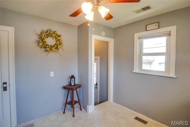 foyer entrance featuring light floors and ceiling fan