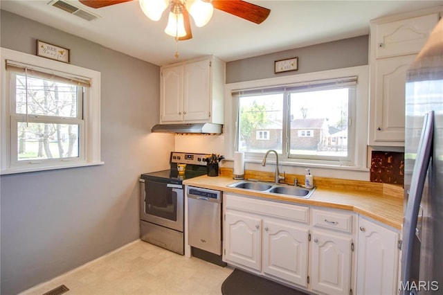 kitchen featuring a sink, appliances with stainless steel finishes, a ceiling fan, white cabinetry, and under cabinet range hood