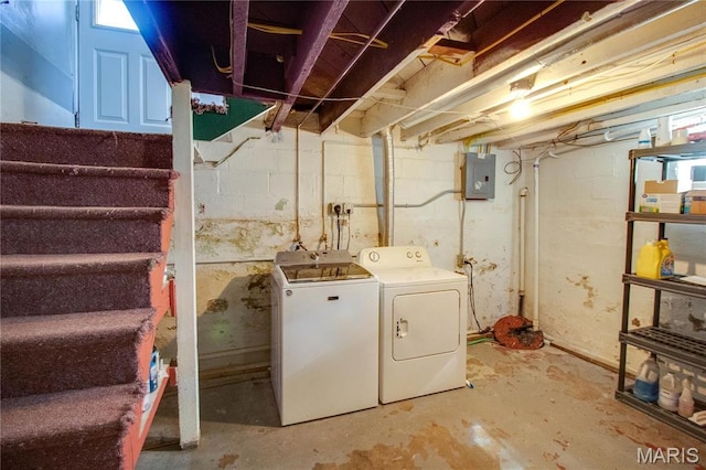 clothes washing area with electric panel and washer and dryer