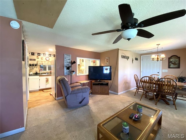 1920 Choctaw Path, Hermann, MO 65041 - living area featuring light carpet, ceiling fan, a textured ceiling, a chandelier, and baseboards