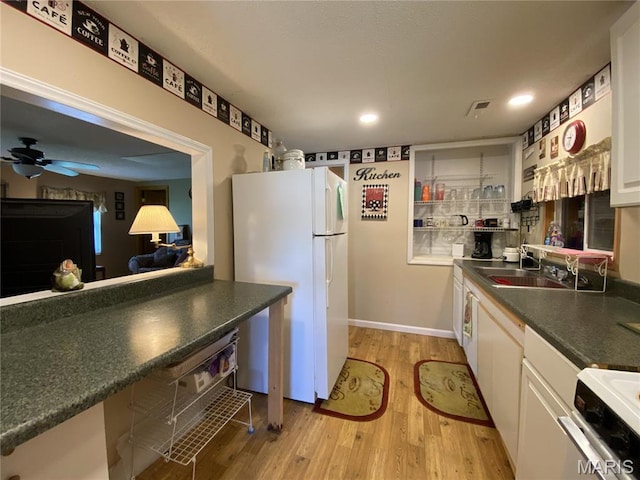 1920 Choctaw Path, Hermann, MO 65041 - kitchen with freestanding refrigerator, stove, light wood finished floors, a sink, and white cabinets