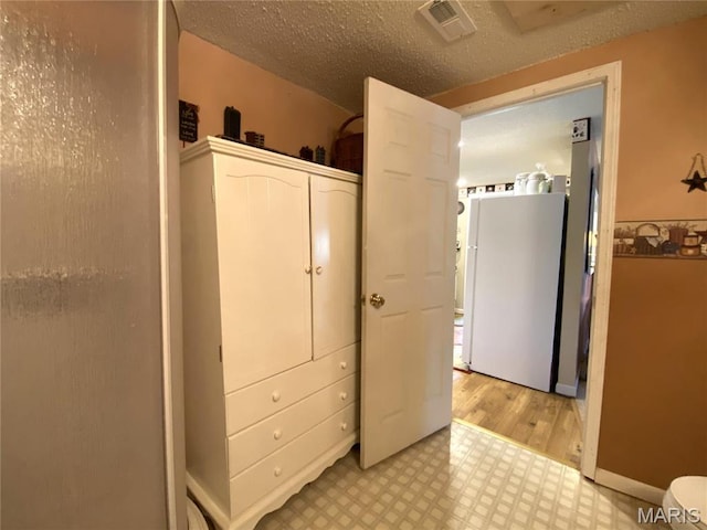 1920 Choctaw Path, Hermann, MO 65041 - bedroom featuring light flooring, freestanding refrigerator, and a textured ceiling