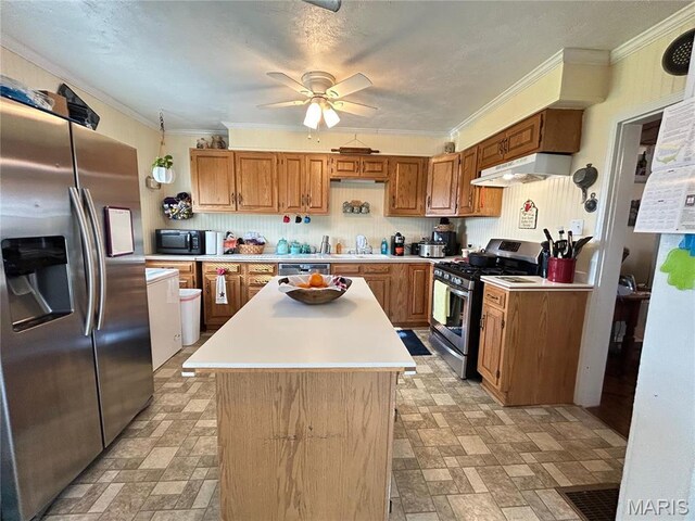 705 E Gibbs St, Salem, MO 65560 - kitchen featuring stainless steel appliances, under cabinet range hood, light countertops, a kitchen island, and ornamental molding