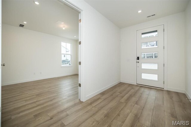 foyer featuring light wood finished floors, baseboards, and recessed lighting