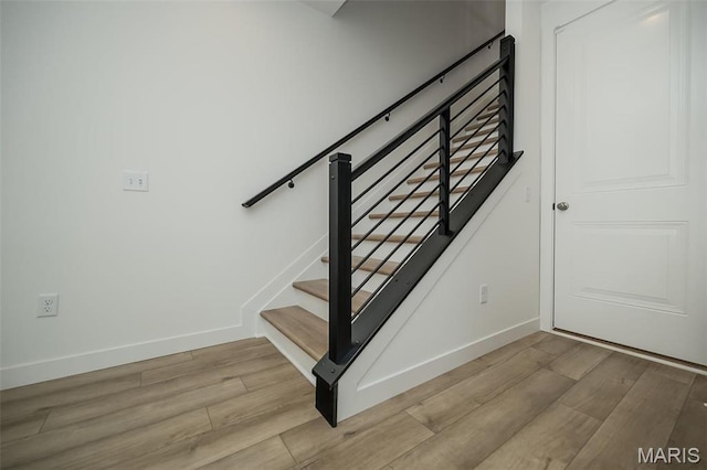 staircase with wood finished floors and baseboards