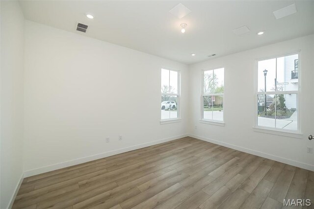 unfurnished room with light wood finished floors, baseboards, and recessed lighting