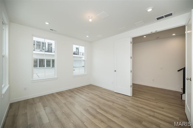 unfurnished room with light wood-style flooring, baseboards, and recessed lighting