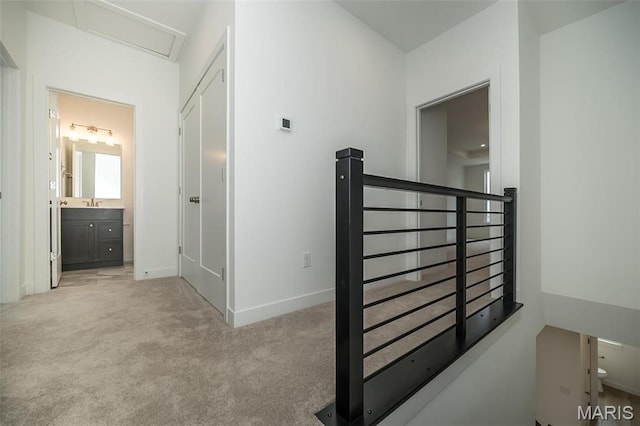 hall with carpet, an upstairs landing, and baseboards