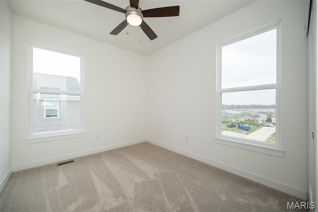 unfurnished room featuring carpet, plenty of natural light, and baseboards