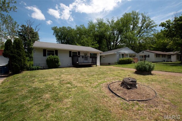 135 Dundee Cir, Saint Louis, MO 63137 - single story home with an outdoor fire pit, a front lawn, and a wooden deck