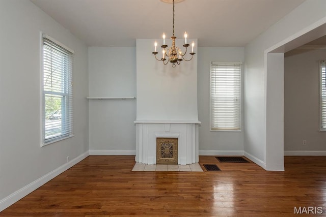 4340 Arsenal St, Saint Louis, MO 63116 - unfurnished living room with a chandelier, healthy amount of natural light, wood finished floors, and baseboards
