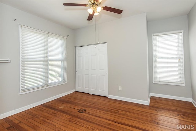 4340 Arsenal St, Saint Louis, MO 63116 - unfurnished bedroom with wood-type flooring, multiple windows, and baseboards