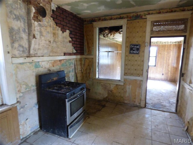5086 Arlington Ave, Saint Louis, MO 63120 - kitchen with gas range, a wood stove, and healthy amount of natural light
