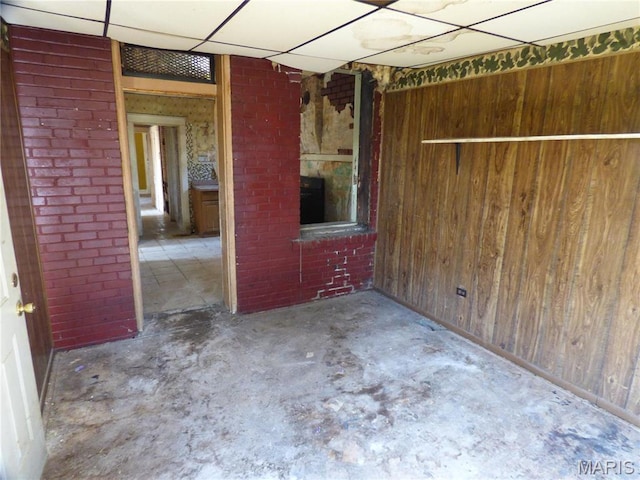 5086 Arlington Ave, Saint Louis, MO 63120 - unfurnished room featuring concrete flooring, wood walls, and a fireplace