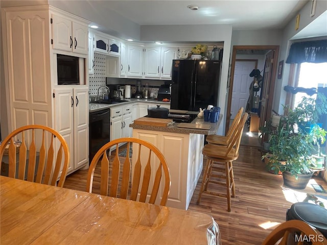 4101 Juedeman Rd, Mo, MO 65453 - kitchen featuring black appliances, a sink, white cabinets, dark wood finished floors, and a center island