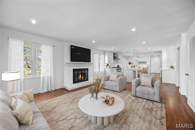 1304 Brynnwood Dr, Saint Louis, MO 63124 - living area featuring plenty of natural light, recessed lighting, light wood finished floors, a brick fireplace, and baseboards