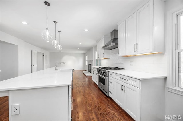 1304 Brynnwood Dr, Saint Louis, MO 63124 - kitchen with wall chimney range hood, high end range, a sink, dark wood finished floors, and backsplash