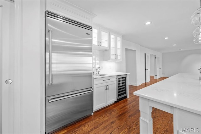 1304 Brynnwood Dr, Saint Louis, MO 63124 - kitchen with built in fridge, wine cooler, white cabinetry, recessed lighting, and dark wood-style floors