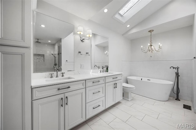 1304 Brynnwood Dr, Saint Louis, MO 63124 - full bath with a skylight, a chandelier, marble look tiles, double vanity, and a soaking tub