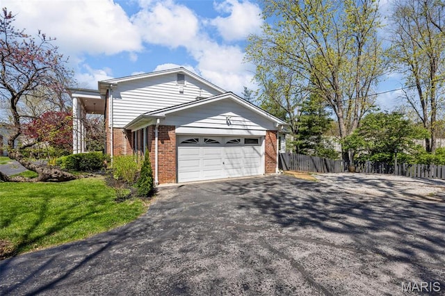 1304 Brynnwood Dr, Saint Louis, MO 63124 - view of property exterior featuring brick siding, asphalt driveway, and a garage