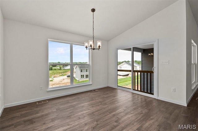 unfurnished dining area with a chandelier, vaulted ceiling, dark wood-type flooring, and baseboards