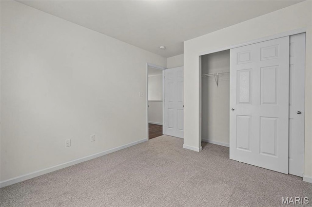 unfurnished bedroom with carpet, baseboards, and a closet