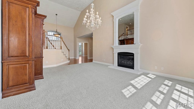 9108 Wiltshire Dr, Columbia, IL 62236 - unfurnished living room featuring carpet floors, stairway, a glass covered fireplace, high vaulted ceiling, and baseboards