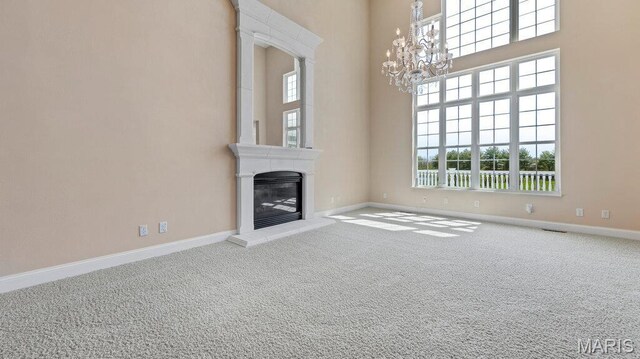 9108 Wiltshire Dr, Columbia, IL 62236 - unfurnished living room with a chandelier, carpet floors, a glass covered fireplace, baseboards, and a towering ceiling