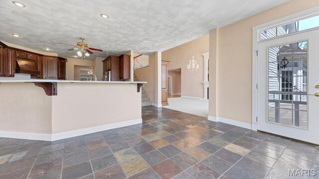 9108 Wiltshire Dr, Columbia, IL 62236 - kitchen featuring stone tile flooring, a kitchen bar, baseboards, light countertops, and under cabinet range hood