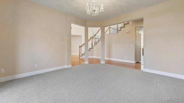 9108 Wiltshire Dr, Columbia, IL 62236 - spare room featuring carpet flooring, a chandelier, stairway, and baseboards