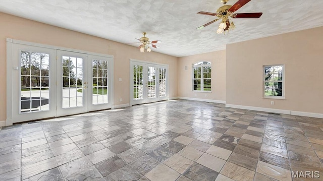 9108 Wiltshire Dr, Columbia, IL 62236 - spare room with a ceiling fan, baseboards, stone tile floors, french doors, and a textured ceiling