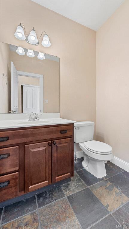 9108 Wiltshire Dr, Columbia, IL 62236 - bathroom with toilet, baseboards, vanity, and stone tile flooring