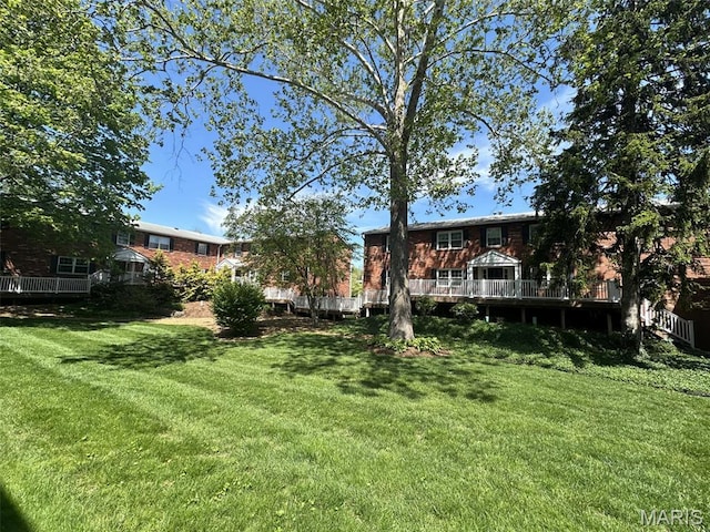 view of grassy yard with a deck