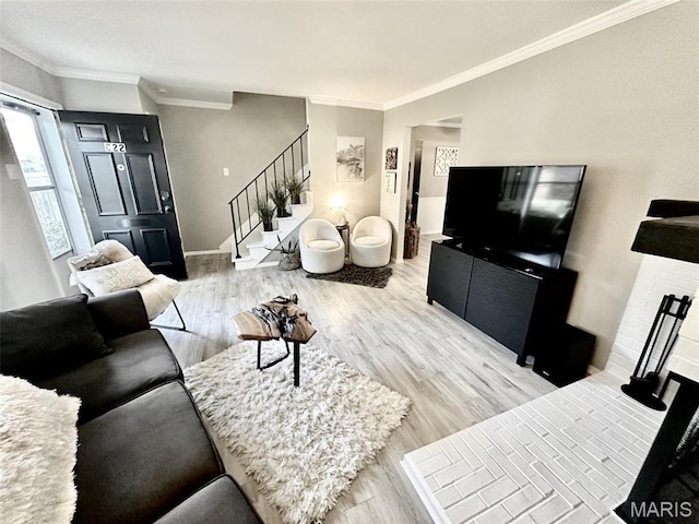 living area with stairway, light wood-style floors, ornamental molding, baseboards, and a fireplace