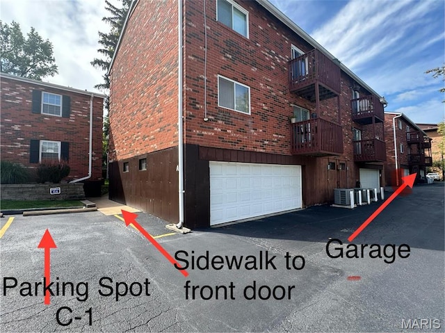 view of building exterior featuring central AC and an attached garage