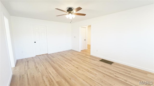 spare room with ceiling fan, light wood finished floors, and baseboards