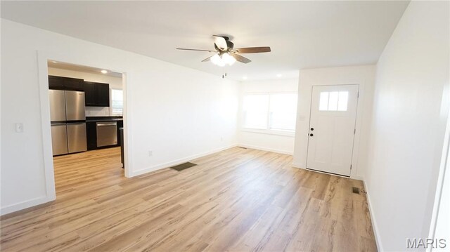 unfurnished living room with light wood-type flooring, baseboards, and a ceiling fan