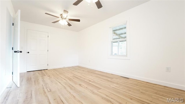 unfurnished room with ceiling fan, light wood-type flooring, and baseboards