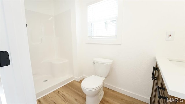 full bath featuring wood finished floors, toilet, baseboards, and vanity