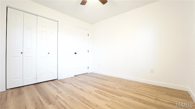 unfurnished bedroom featuring light wood-style floors, baseboards, a closet, and a ceiling fan